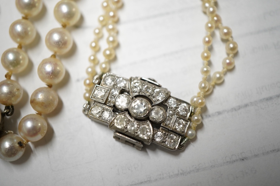 Two double strand cultured pearl necklaces, one graduated with paste set white metal clasp, 48cm, the other with cultured pearl set 9ct white gold clasp.